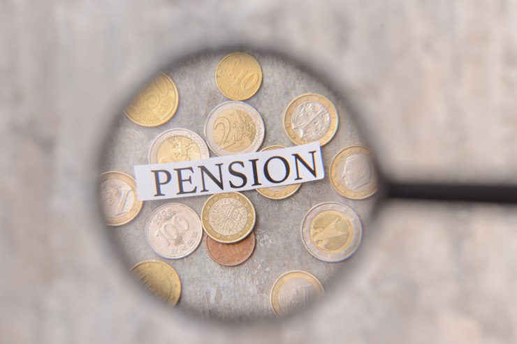 lente d'ingrandimento su monete euro e scritta "pension"