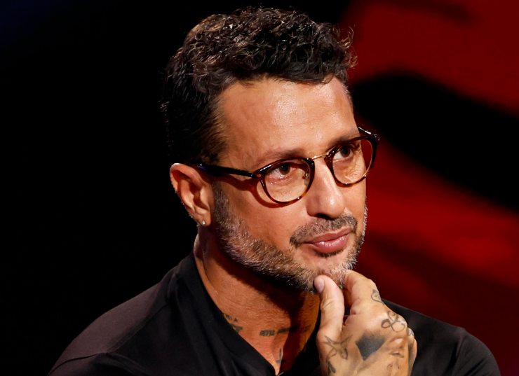 Fabrizio Corona si regge il mento con la mano