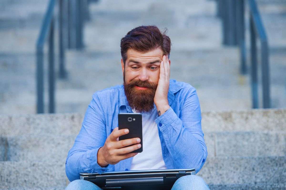 Uomo seduto sulle scale con espressione perplessa