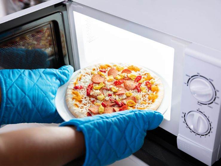 microonde in cui viene messa una pizza