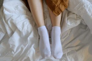 Gambe con calzini sul letto