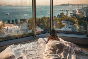 Ragazza che guarda dalla finestra sul letto