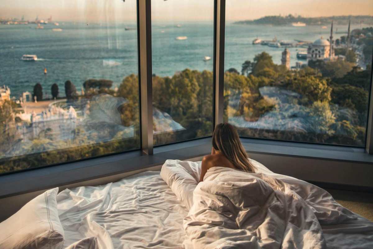 Ragazza che guarda dalla finestra sul letto