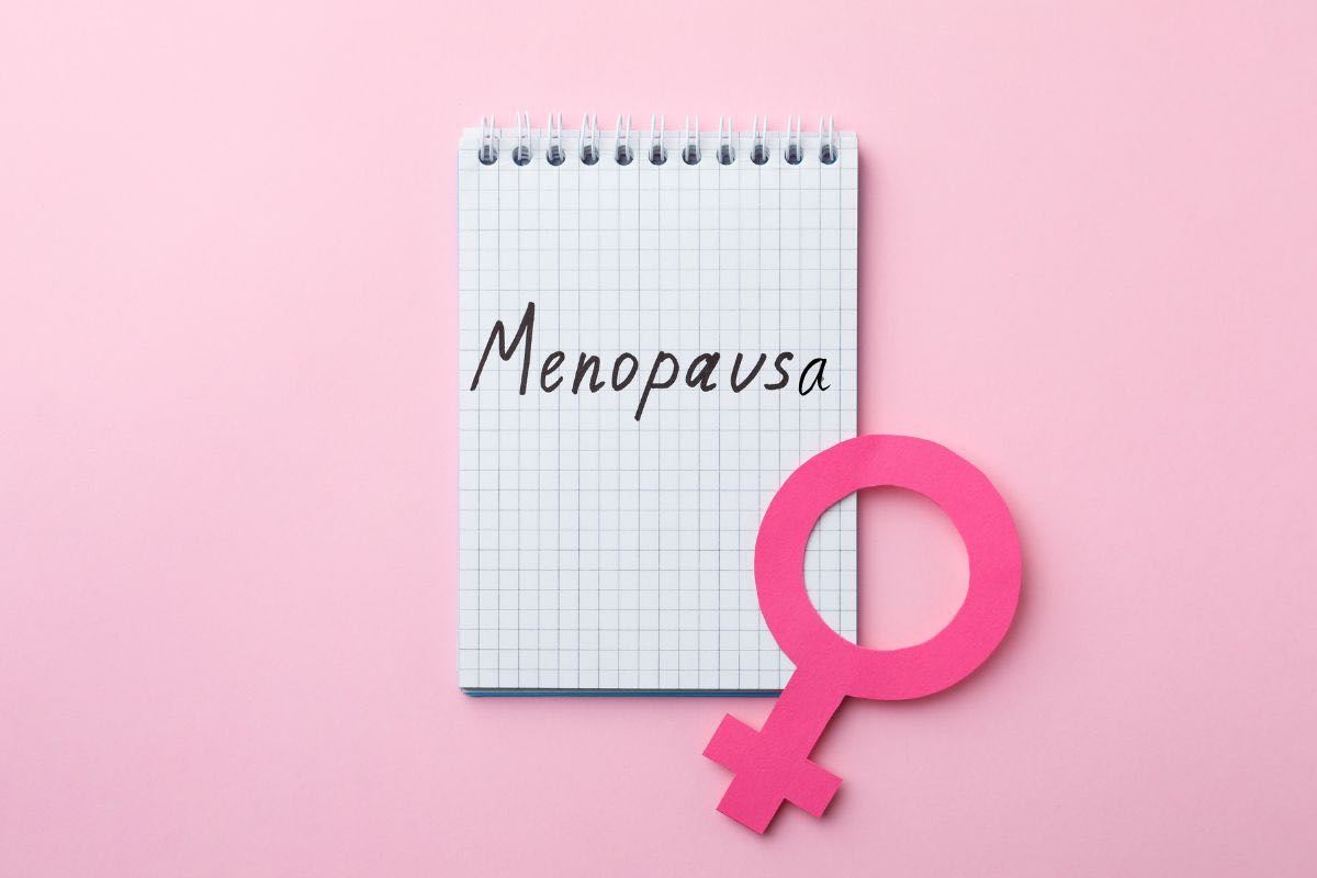 Bloc-notes con scritto menopausa e simbolo femminile