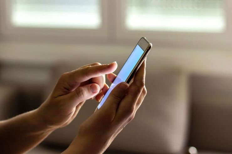 Mano usano smartphone con schermo illuminato