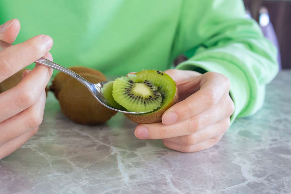 Persona che mangia kiwi