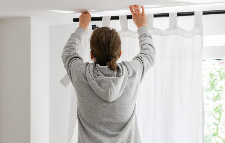 donna appende tenda bianca