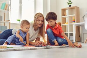 Ragazza alla pari che gioca con due bambini