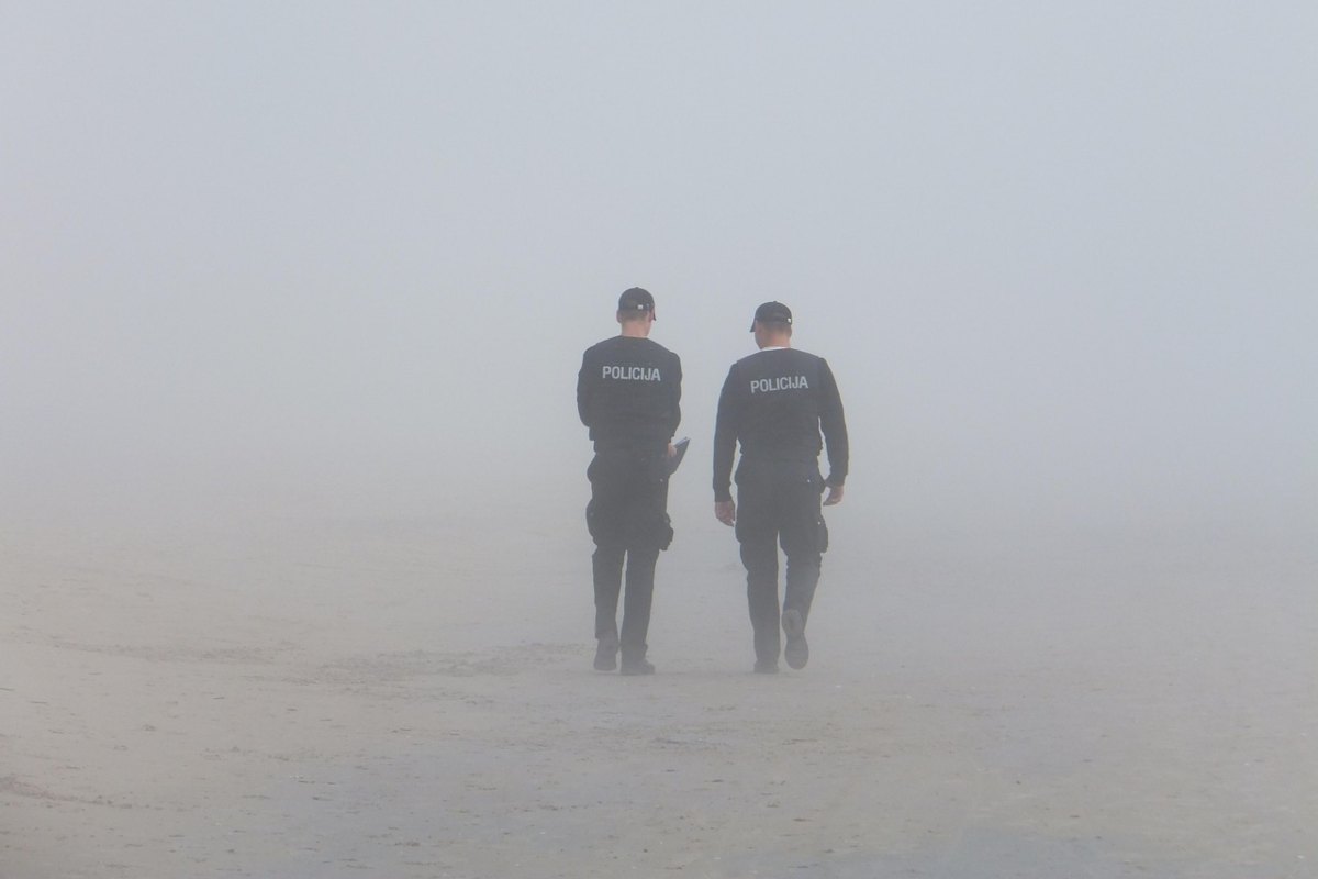 Coppia di agenti che cammina in mezzo alla nebbia