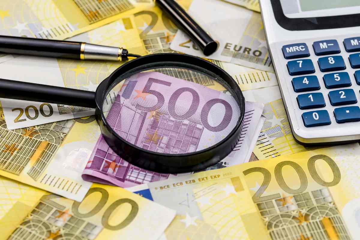 Lente d'ingrandimento sopra a banconote euro. Focus su 500€