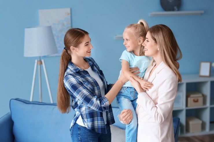 Ragazza alla pari che parla con una mamma e sua figlia a casa loro