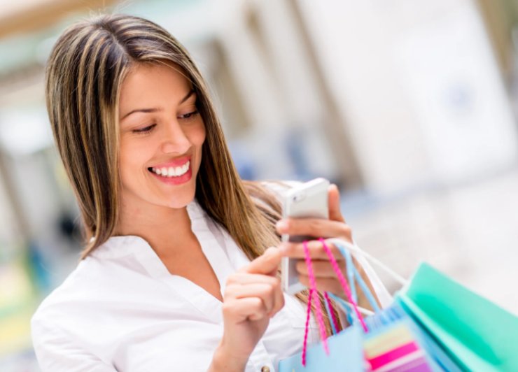 donna che sorride con il cellulare in mano