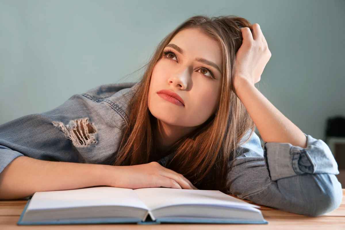 Ragazza distratta con la testa su una mano