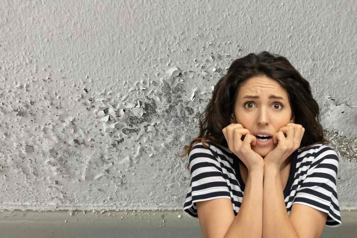 umidità muro e donna spavenata