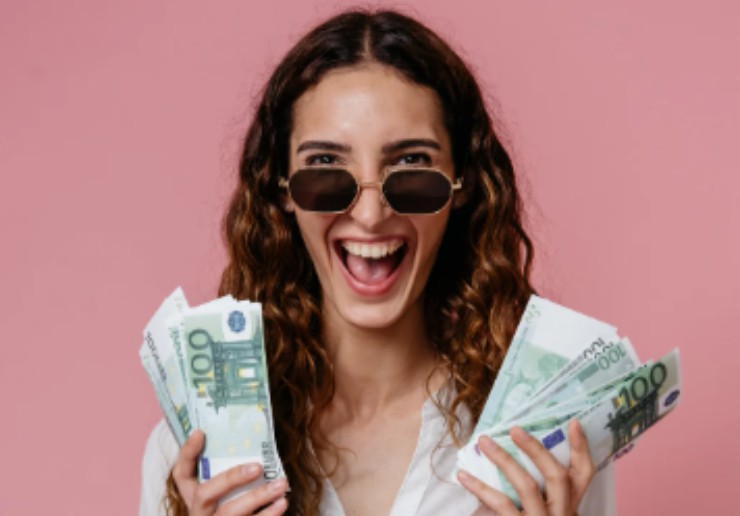 ragazza che sorride con dei soldi nelle mani