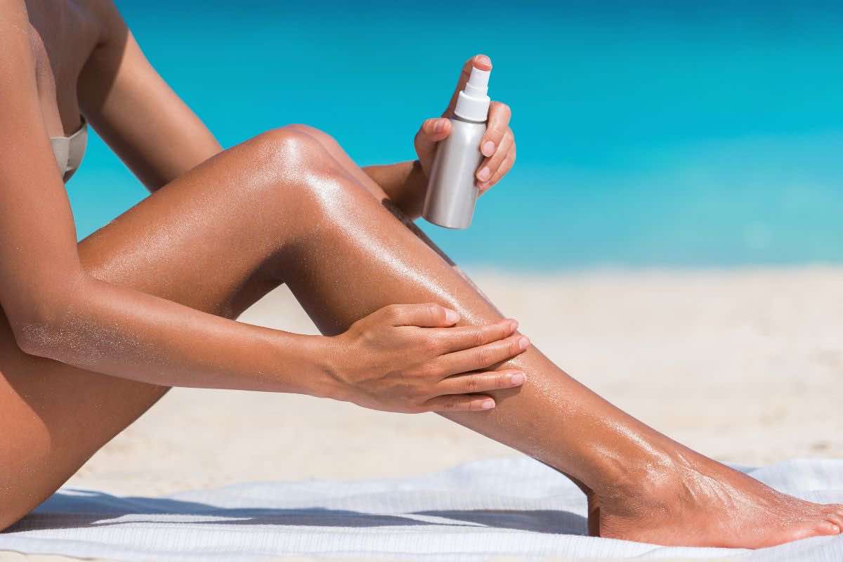Donna che si spalma crema sulle gambe
